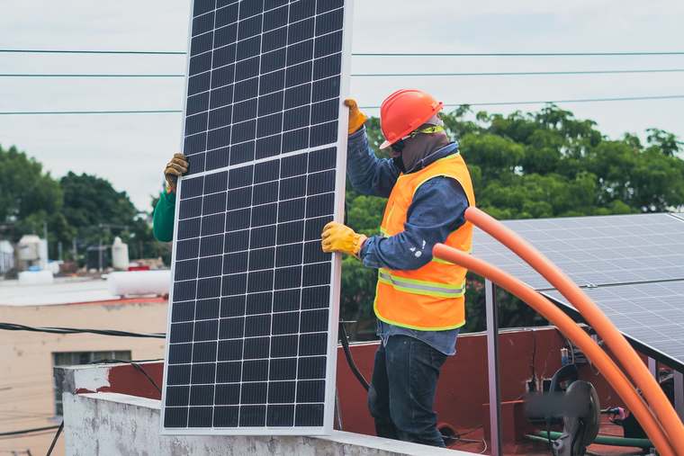 An installer fitting solar panels on a roof