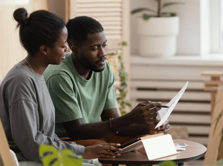 A couple reading a document together at a table at home